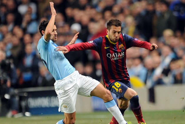 Manchester City's Jesus Navas, left, tackles Barcelona's Jordi Alba during their Champions League last-16 round soccer match at the Etihad Stadium in Manchester, England, Tuesday, Feb. 18, 2014. (AP Photo/Clint Hughes)