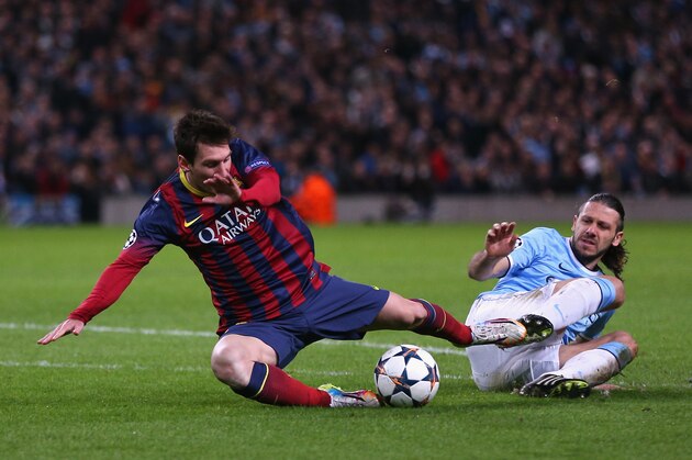 MANCHESTER, ENGLAND - FEBRUARY 18:  Martin Demichelis of Manchester City fouls Lionel Messi of Barcelona to concede a penalty and is subsequently sent off during the UEFA Champions League Round of 16 first leg match between Manchester City and Barcelona at the Etihad Stadium on February 18, 2014 in Manchester, England.  (Photo by Clive Brunskill/Getty Images)