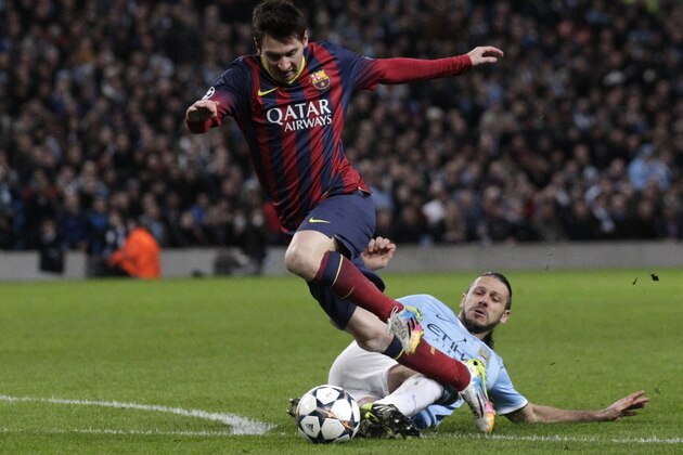 Barcelona's Lionel Messi is tackled down by Manchester City's Martin Demichelis and receives a penalty kick during their Champions League first knock out round soccer match at the Etihad Stadium, Manchester, England, Tuesday Feb. 18, 2014. (AP Photo/Jon Super)