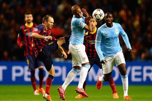 MANCHESTER, ENGLAND - FEBRUARY 18:  Andres Iniesta of Barcelona competes with Fernandinho of Manchester City during the UEFA Champions League Round of 16 first leg match between Manchester City and Barcelona at the Etihad Stadium on February 18, 2014 in Manchester, England.  (Photo by Laurence Griffiths/Getty Images)