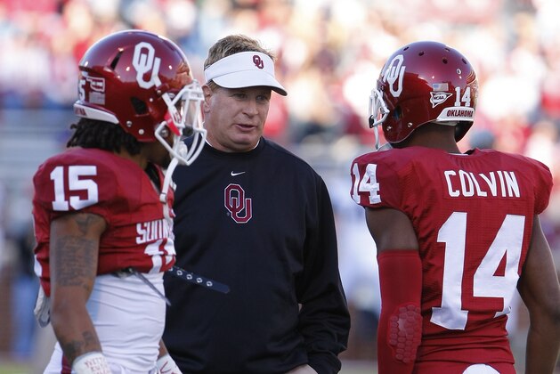 Oklahoma Defensive Coordinator Mike Stoops, center, talks with Zach Sanchez, left, and Aaron Colvin, right, before the start of an NCAA college football game against TCU on Saturday, Oct. 5, 2013, in Norman, Okla. (AP Photo/Alonzo Adams)