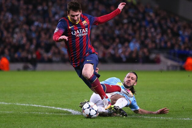 MANCHESTER, ENGLAND - FEBRUARY 18:  Martin Demichelis of Manchester City fouls Lionel Messi of Barcelona to concede a penalty and is subsequently sent off during the UEFA Champions League Round of 16 first leg match between Manchester City and Barcelona at the Etihad Stadium on February 18, 2014 in Manchester, England.  (Photo by Clive Brunskill/Getty Images)