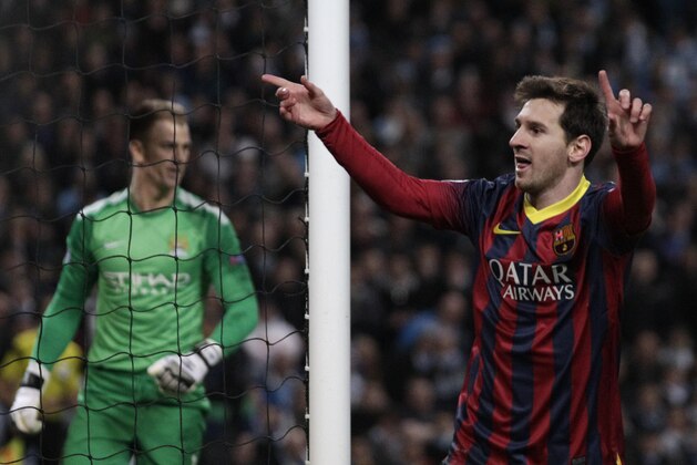Manchester City's goalkeeper Joe Hart reacts as Barcelona's Lionel Messi celebrates after he scores the first goal of the game from a penalty during the Champions League first knock out round soccer match between Barcelona and Manchester City at the Etihad Stadium, Manchester, England, Tuesday Feb. 18, 2014. (AP Photo/Jon Super)