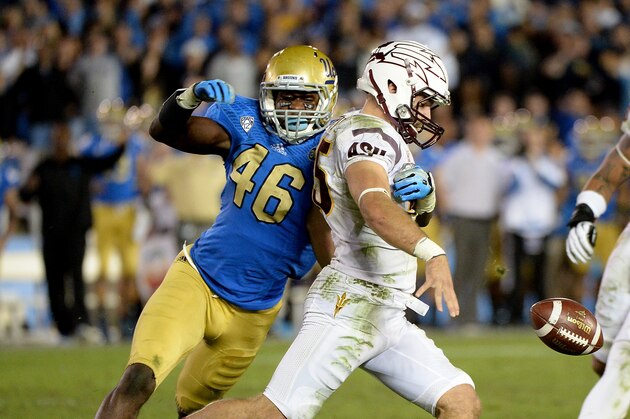 PASADENA, CA - NOVEMBER 23:  Punter Alex Garoutte #25 of the Arizona State Sun Devils fails to kick the ball as he is tackled by Kenny Orjioke #46 of the UCLA Bruins in front of Carl Bradford #52 for a loss during the third quarter against the UCLA Bruins at Rose Bowl on November 23, 2013 in Pasadena, California.  (Photo by Harry How/Getty Images)