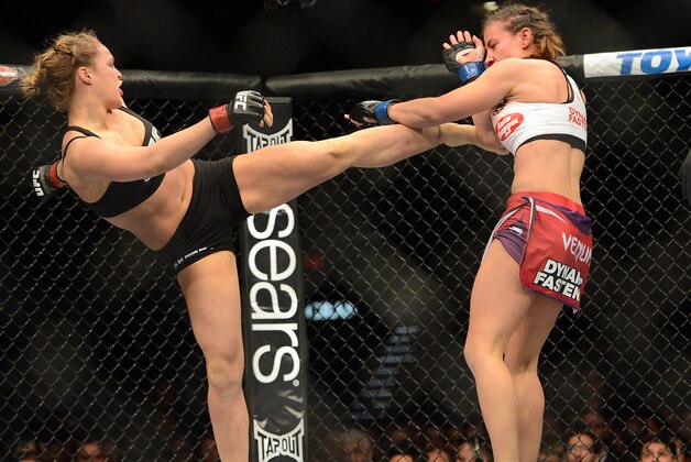 Dec 28, 2013; Las Vegas, NV, USA;    Ronda Rousey (red gloves) and Miesha Tate (blue gloves) during their UFC Women's Bantamweight Championship Bout at the MGM Grand Garden Arena. Ronda Rousey won Mandatory Credit: Jayne Kamin-Oncea-USA TODAY Sports