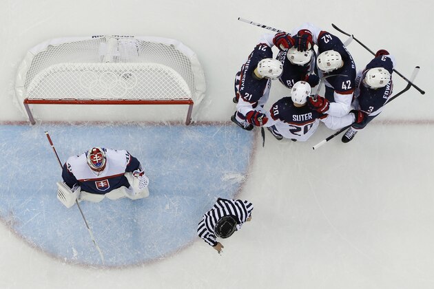Team USA celebrates Phil Kessel's (81) goal against Slovakia goaltender Jaroslav Halak during the 2014 Winter Olympics men's ice hockey game at Shayba Arena, Thursday, Feb. 13, 2014, in Sochi, Russia. (AP Photo/Matt Slocum)