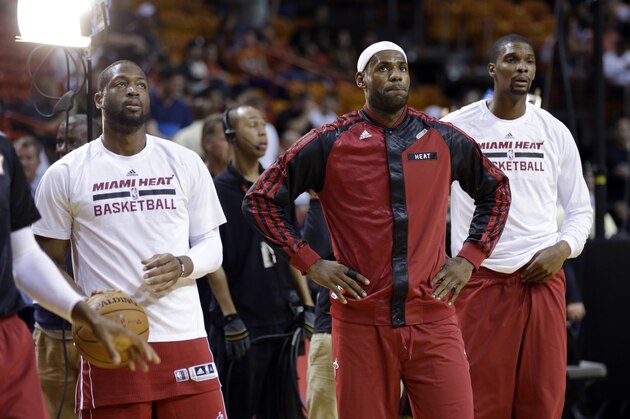 Miami Heat's Dwyane Wade, left, LeBron James, center, and Chris Bosh, right, stand on the court during warm-ups before an NBA basketball game against the Charlotte Bobcats, Sunday, Dec. 1, 2013, in Miami. (AP Photo/Lynne Sladky)