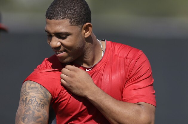St. Louis Cardinals' Oscar Taveras shows off a tattoo as he heads out for an informal spring training baseball practice Wednesday, Feb. 12, 2014, in Jupiter, Fla. Taveras, one of the Cardinals' top prospects, missed much of the 2013 due to an ankle injury. (AP Photo/Jeff Roberson)
