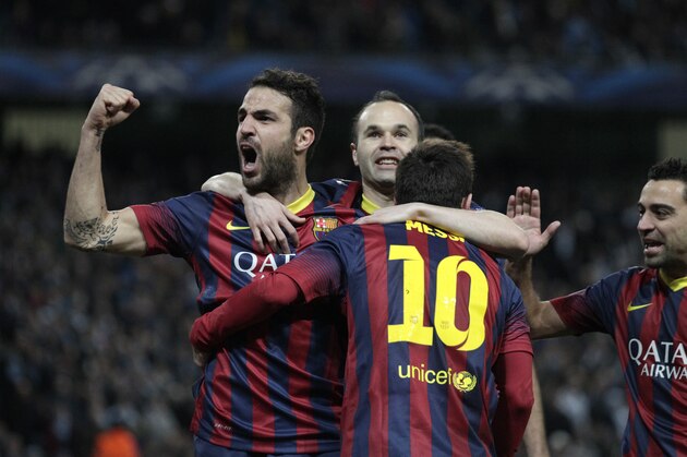 Barcelona's Lionel Messi, center, celebrates scoring the opening goal from a penalty with team mates Cesc Fabregas, left, and Andres Hiniesta during the Champions League first knock out round soccer match between Barcelona and Manchester City at the Etihad Stadium, Manchester, England, Tuesday Feb. 18, 2014. (AP Photo/Jon Super)