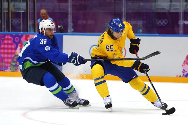 SOCHI, RUSSIA - FEBRUARY 19: Erik Karlsson #65 of Sweden handles the puck against Jan Mursak #39 of Slovenia in the first period during the Men's Ice Hockey Quarterfinal Playoff on Day 12 of the 2014 Sochi Winter Olympics at Bolshoy Ice Dome on February 19, 2014 in Sochi, Russia.  (Photo by Martin Rose/Getty Images)