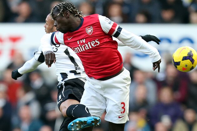 Newcastle United's Yoan Gouffran, left, vies for the ball with Arsenal's Bacray Sagna, right, during their English Premier League soccer match at St James' Park, Newcastle, England, Sunday, Dec. 29, 2013. (AP Photo/Scott Heppell)