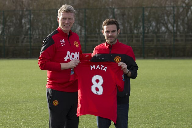 Manchester United's new signing Juan Mata, right, displays his new shirt alongside manager David Moyes before a press conference at the team's Carrington training ground, Manchester, England, Monday, Jan. 27, 2014. With Manchester United in danger of missing out on the Champions League next season, Juan Mata's arrival at Old Trafford for a club record fee of 37.1 million pounds ($61.2 million) is certainly an emergency move. But it also marks the first step in the rebuilding process of England's most titled club. After a botched transfer campaign last summer that was followed by the club's lackluster first half of the season, United now looks determined to allow manager David Moyes the opportunity to build his own team.(AP Photo/Jon Super)