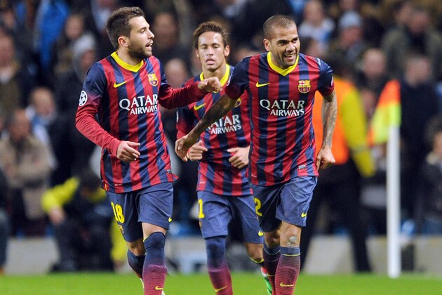 Barcelona's Daniel Alves, right, celebrates with teammate Jordi Alba, left, after he scored the second goal of the game for his side during their Champions League Round of 16 soccer match against Manchester City at the Etihad Stadium in Manchester, England, Tuesday, Feb. 18, 2014. (AP Photo/Clint Hughes)