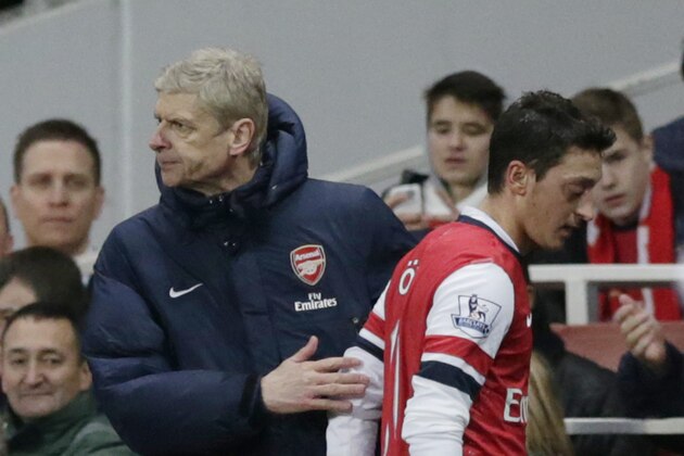 Arsenal's Mesut Ozil, right, is patted by his French manager Arsene Wenger after being substituted off during the English Premier League soccer match between Arsenal and Fulham at the Emirates Stadium in London, Saturday, Jan. 18, 2014.  (AP Photo/Matt Dunham)