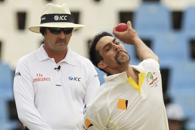 Australia's bowler Mitchell Johnson bowls as umpire Richard Illingworth, left, of England watches on the third day of their their cricket test match at Centurion Park in Pretoria, South Africa, Friday, Feb. 14, 2014. (AP Photo/Themba Hadebe)
