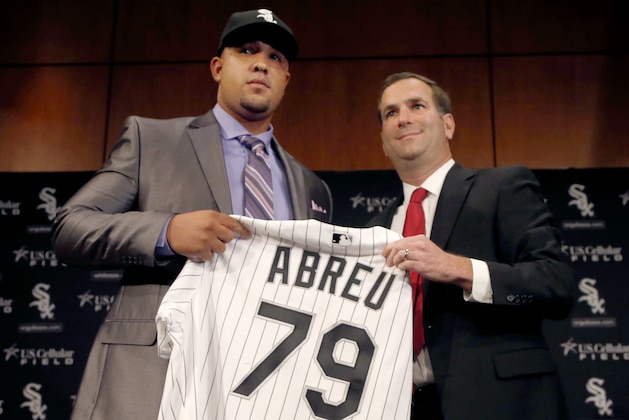 Cuban slugger Jose Abreu, left, smiles with Chicago White Sox  General Manager Rick Hahn during a news conference where Hahn announced a six-year, $68 million deal with Abreu Tuesday, Oct. 29, 2013, in Chicago. The 26-year-old Abreu will receive a signing bonus of $10 million and earn $7 million in 2014. (AP Photo/Charles Rex Arbogast)