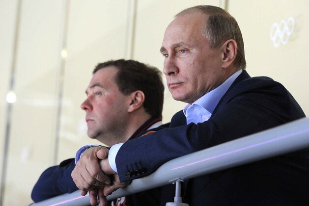 In this Sunday, Feb. 16, 2014 photo, Russian President Vladimir Putin, right, and Prime Minister Dmitry Medvedev watch an ice hockey game between Russia and Slovakia at the 2014 Winter Olympics in Sochi, Russia. (AP Photo/RIA-Novosti, Mikhail Klimentyev, Presidential Press Service)