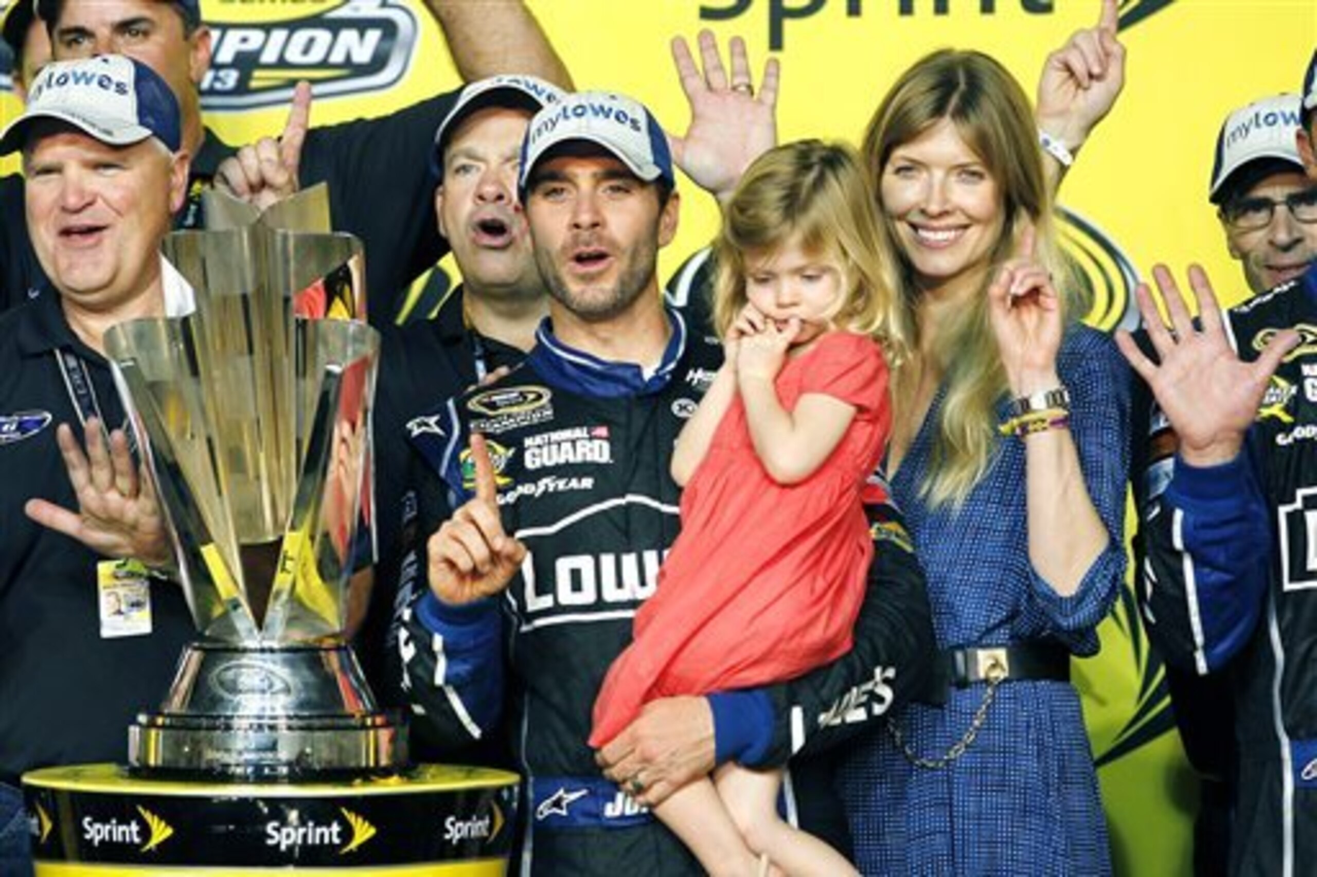 Jimmie Johnson, center, his wife, Chandra, and his daughter, Genevieve, celebrate after he won his sixth NASCAR Sprint Cup Series championship in Homestead, Fla., Sunday, Nov. 17, 2013. (AP Photo/Terry Renna)