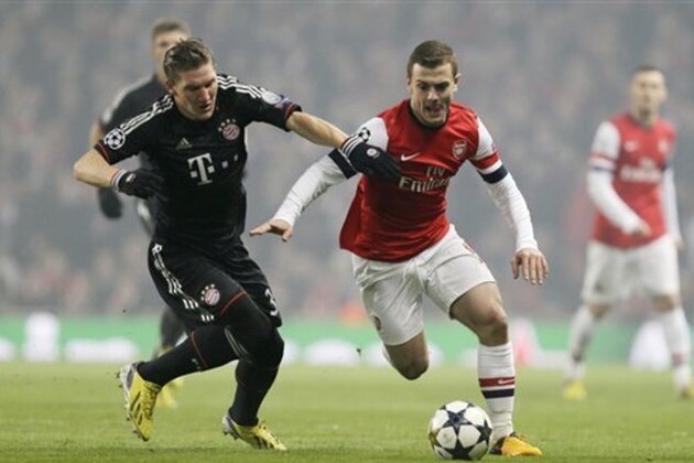 Bayern's Bastian Schweinsteiger, left, tackles Arsenal's Jack Wilshere during a Champions League, round of 16, first leg soccer match between Arsenal and Bayern Munich at Arsenal's Emirates stadium in London, Tuesday, Feb.  19, 2013.(AP Photo/Alastair Grant)