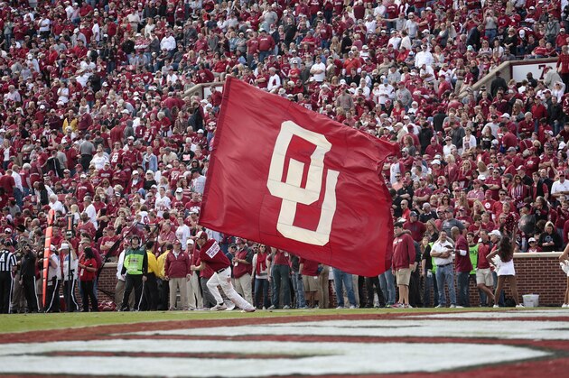 NORMAN, OK - NOVEMBER 16:  A member of the Oklahoma Sooners spirit squad waves a flag after a touchdown against the Iowa State Cyclones November 16, 2013 at Gaylord Family-Oklahoma Memorial Stadium in Norman, Oklahoma. Oklahoma defeated Iowa State 48-10. (Photo by Brett Deering/Getty Images)
