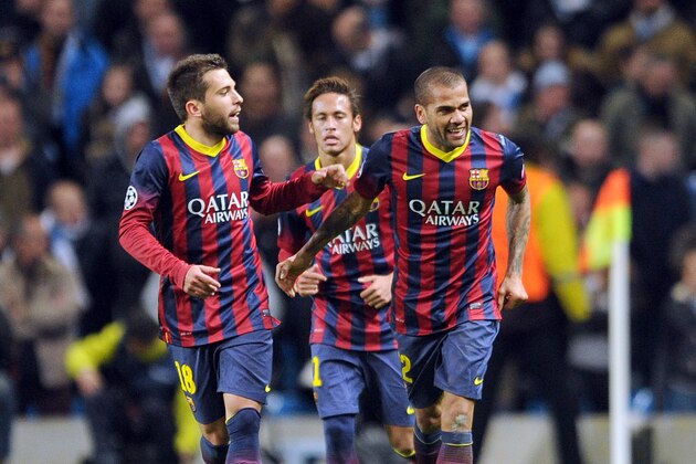 Barcelona's Daniel Alves, right, celebrates with teammate Jordi Alba, left, after he scored the second goal of the game for his side during their Champions League Round of 16 soccer match against Manchester City at the Etihad Stadium in Manchester, England, Tuesday, Feb. 18, 2014. (AP Photo/Clint Hughes)