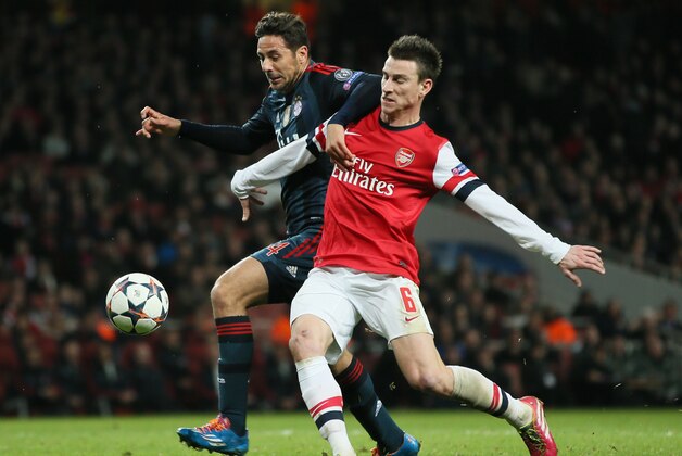 Arsenal's Laurent Koscielny, right, and Bayern's Claudio Pizarro challenge for the ball during a Champions League, round of 16, first leg soccer match between Arsenal and Bayern Munich at the Emirates stadium in London, Wednesday, Feb. 19, 2014 .(AP Photo/Alastair Grant)