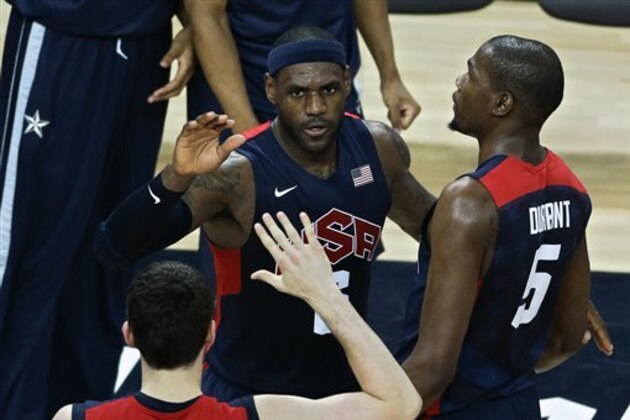 United States' Lebron James, center, is congratulated by teammates Kevin Durant, right, and Kevin Love, bottom, after slamming a dunk in a men's basketball semifinal game against Argentina at the 2012 Summer Olympics, Friday, Aug. 10, 2012, in London. (AP Photo/Victor R. Caivano)