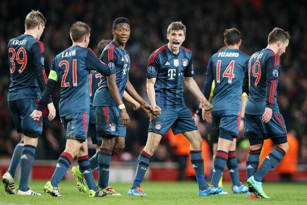 Bayern's Thomas Mueller, center, celebrates his side's second goal during a Champions League, round of 16, first leg soccer match between Arsenal and Bayern Munich at the Emirates stadium in London, Wednesday, Feb. 19, 2014 .(AP Photo/Alastair Grant)