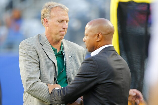 Aug 24, 2013; East Rutherford, NJ, USA; New York Jets general manager John Idzik, Jr (left) and New York Giants general manager Jerry Reese (right) exchange greetings prior to the game at MetLife Stadium. Mandatory Credit: Jim O'Connor-USA TODAY Sports