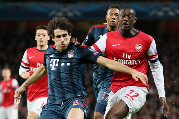 Arsenal's Yaya Sanogo, right, and Bayern's Javier Martinez challenge for the ball during a Champions League, round of 16, first leg soccer match between Arsenal and Bayern Munich at the Emirates stadium in London, Wednesday, Feb. 19, 2014 .(AP Photo/Alastair Grant)