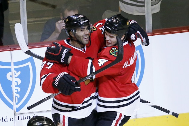 Chicago Blackhawks defenseman Johnny Oduya, left, celebrates his goal with defenseman Niklas Hjalmarsson during the second period of an NHL hockey game against the Dallas Stars, Tuesday, Dec. 3, 2013, in Chicago. (AP Photo/Charles Rex Arbogast)
