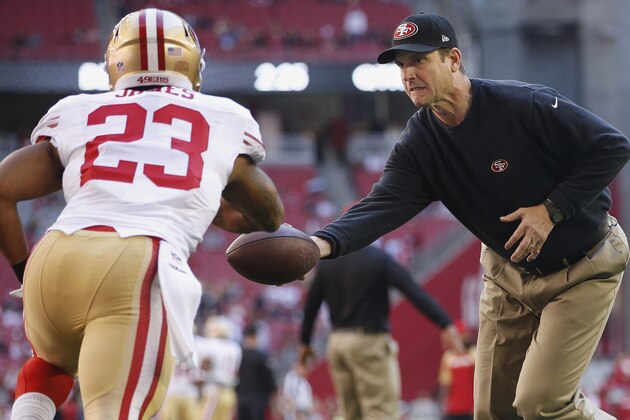 San Francisco 49ers head coach Jim Harbaugh hands the ball off to LaMichael James (23) as the team warms up prior to an NFL football game against the Arizona Cardinals Sunday, Dec. 29, 2013, in Glendale, Ariz. (AP Photo/Ross D. Franklin)