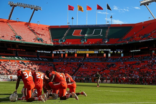 MIAMI GARDENS, FL - NOVEMBER 23: Members of the Miami Hurricanes wait out an injury during a game against the Virginia Cavaliers at Sun Life Stadium on November 23, 2013 in Miami Gardens, Florida.  (Photo by Mike Ehrmann/Getty Images)
