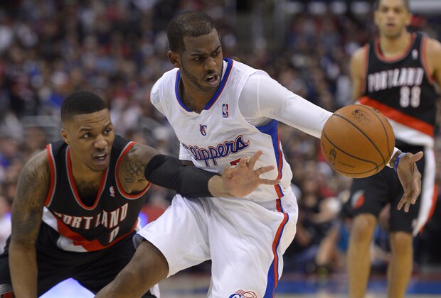Portland Trail Blazers guard Damian Lillard, left, and Los Angeles Clippers guard Chris Paul reach for a loose ball during the second half of an NBA basketball game, Wednesday, Feb. 12, 2014, in Los Angeles. (AP Photo/Mark J. Terrill)