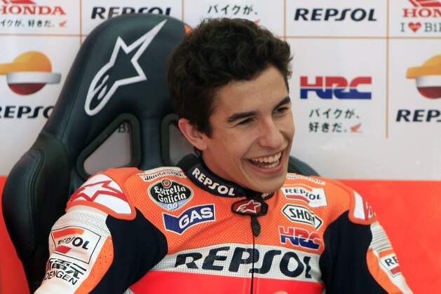 MotoGP rider Marc Marquez of Spain laughs as he speaks to a crew member during a pre-season test at Sepang International Circuit in Sepang, Malaysia, Tuesday, Feb. 4, 2014. (AP Photo/Lai Seng Sin)