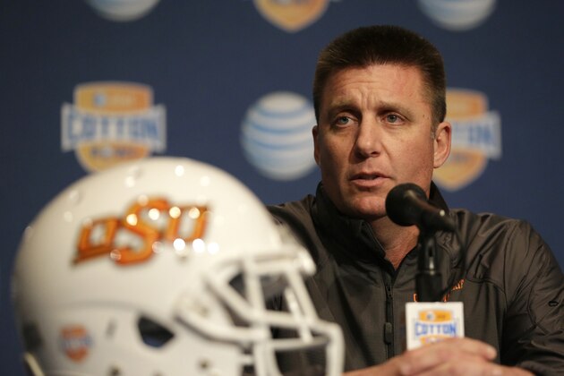 Oklahoma State coach Mike Gundy answers questers from reporters during the AT&T Cotton Bowl Classic media day on Monday, Dec. 30, 2013, in Arlington, Texas.   Missouri will play Oklahoma State in the annual bowl game on Friday.  (AP Photo/Tim Sharp)