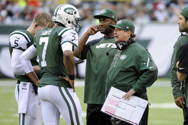 New York Jets offensive coordinator Marty Mornhinweg, right, talks with quarterback Geno Smith during the first half of an NFL football game against the Cleveland Browns Sunday, Dec. 22, 2013, in East Rutherford, N.J.  (AP Photo/Bill Kostroun)