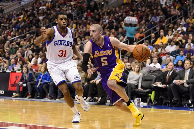 Feb 7, 2014; Philadelphia, PA, USA; Los Angeles Lakers guard Steve Blake (5) is defended by Philadelphia 76ers forward Hollis Thompson (31) during the second quarter at the Wells Fargo Center. The Lakers defeated the Sixers 112-98. Mandatory Credit: Howard Smith-USA TODAY Sports
