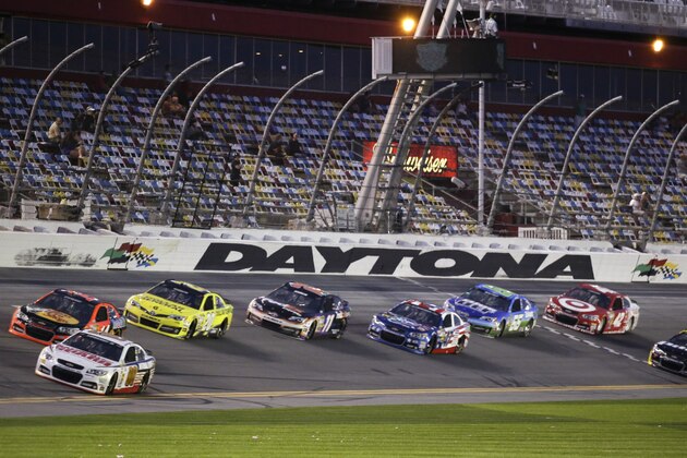 Dale Earnhardt Jr., bottom front, and Tony Stewart, top front, lead a group of cars down the front stretch during an evening practice for the Daytona 500 NASCAR Sprint Cup Series auto race at Daytona International Speedway in Daytona Beach, Fla., Wednesday, Feb. 19, 2014. (AP Photo/John Raoux)