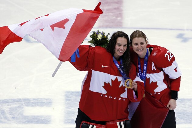 Goalkeeper Shannon Szabados of Canada (1) and Hayley Wickenheiser of Canada (22) celebrate after the medal ceremony in the women's ice hockey tournament at the 2014 Winter Olympics, Friday, Feb. 21, 2014, in Sochi, Russia. Canada won gold after defeated Team USA 3-2 in overtime. (AP Photo/Petr David Josek)