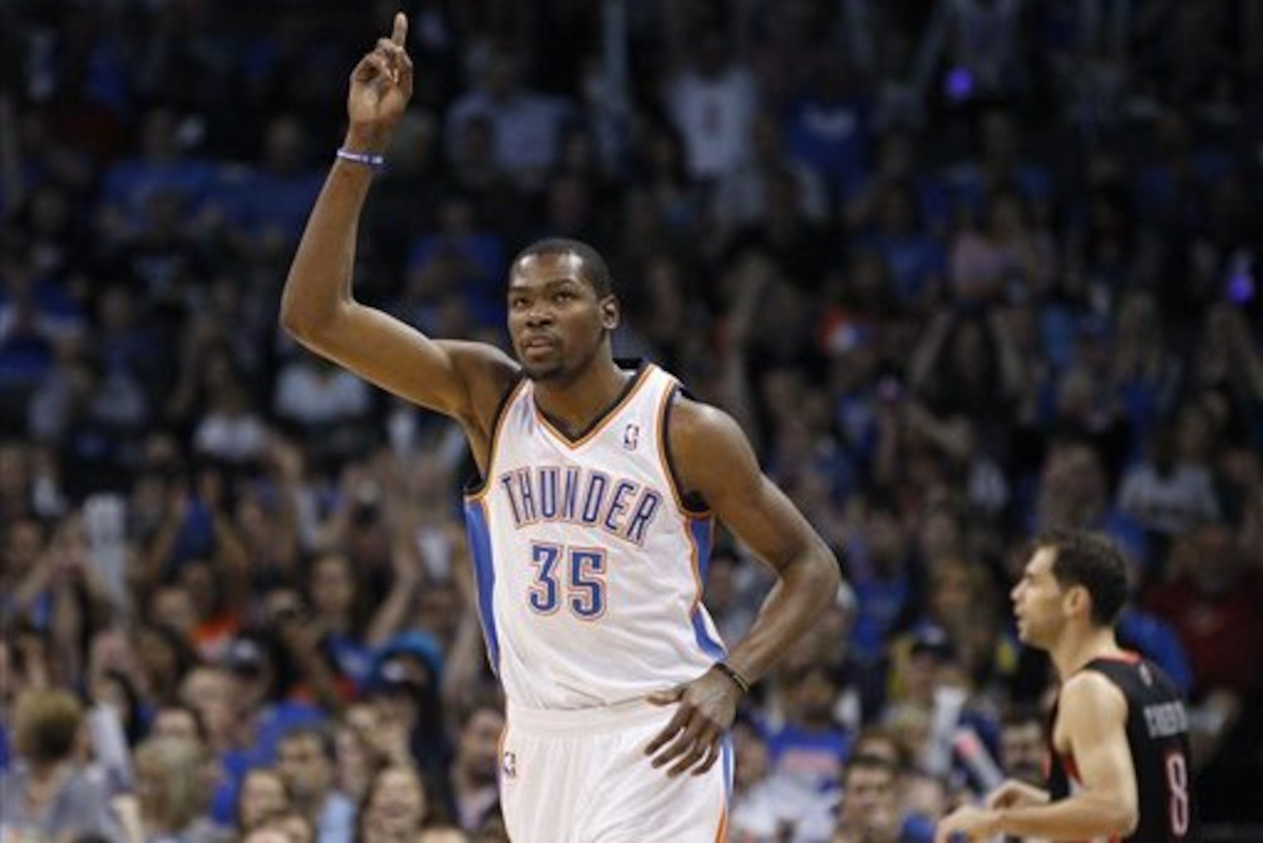 Oklahoma City Thunder forward Kevin Durant (35) reacts to hitting a three-point basket against the Toronto Raptors in the first quarter of an NBA basketball game in Oklahoma City, Sunday, April 8, 2012. Raptors guard Jose Calderson is at right.  (AP Photo/Sue Ogrocki)