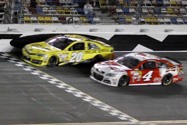 Matt Kenseth (20) races to the finish ahead of Kevin Harvick (4) to win the first of two NASCAR Sprint Cup series qualifying auto races at Daytona International Speedway in Daytona Beach, Fla., Thursday, Feb. 20, 2014. (AP Photo/Terry Renna)