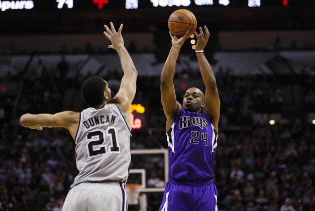 Feb 1, 2014; San Antonio, TX, USA; Sacramento Kings forward Carl Landry (24) shoots against San Antonio Spurs forward Tim Duncan (21) during the second half at AT&T Center. The Spurs won 95-93. Mandatory Credit: Soobum Im-USA TODAY Sports