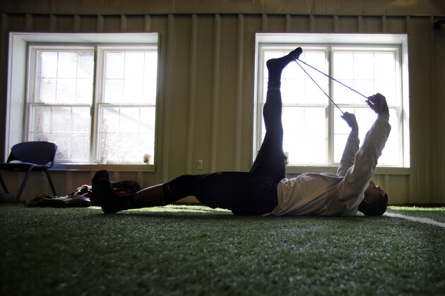 In this Feb. 14, 2014 photo, Bryant University defensive back Stefaun Whitehead stretches during a work out at TEST Sports Clubs in Martinsville, N.J. College football players from across the country come here to prepare for the NFL scouting combine in Indianapolis, the regional combines and their pro days.  (AP Photo/Mel Evans)