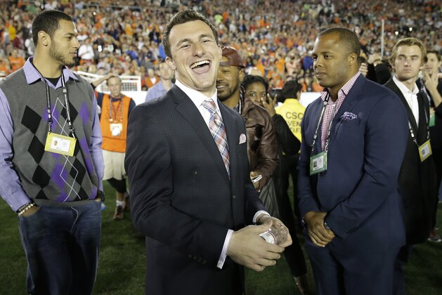 Texas A&M quarterback Johnny Manziel smiles from the sidelines during the first half of the NCAA BCS National Championship college football game between Auburn and Florida State Monday, Jan. 6, 2014, in Pasadena, Calif. (AP Photo/David J. Phillip)