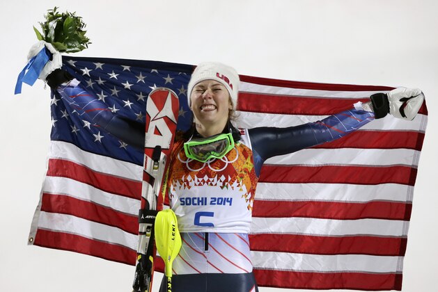 Women's slalom gold medal winner Mikaela Shiffrin of the United States poses for photographers with the U.S. flag at the Sochi 2014 Winter Olympics, Friday, Feb. 21, 2014, in Krasnaya Polyana, Russia.(AP Photo/Gero Breloer)