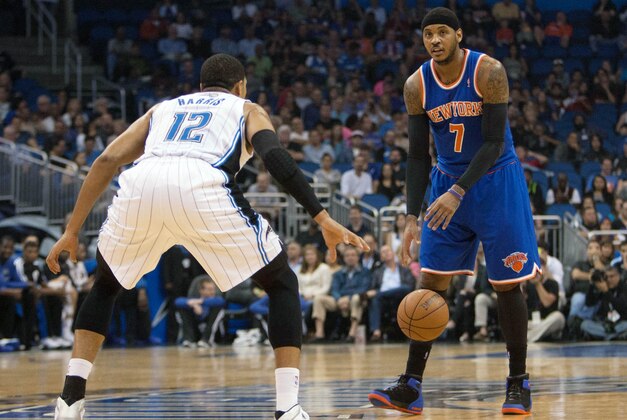 Dec 23, 2013; Orlando, FL, USA; Orlando Magic small forward Tobias Harris (12) defends New York Knicks small forward Carmelo Anthony (7) during the first half of the game at the Amway Center. Mandatory Credit: Rob Foldy-USA TODAY Sports