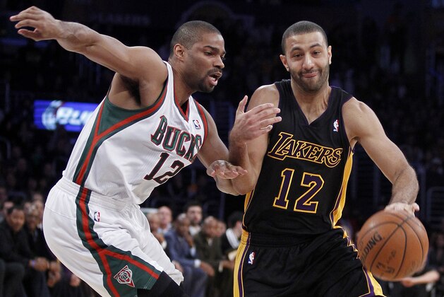 Los Angeles Lakers guard Kendall Marshall, right, drives against Milwaukee Bucks guard Gary Neal during the first half of an NBA basketball game Tuesday, Dec. 31, 2013, in Los Angeles. (AP Photo/Alex Gallardo)