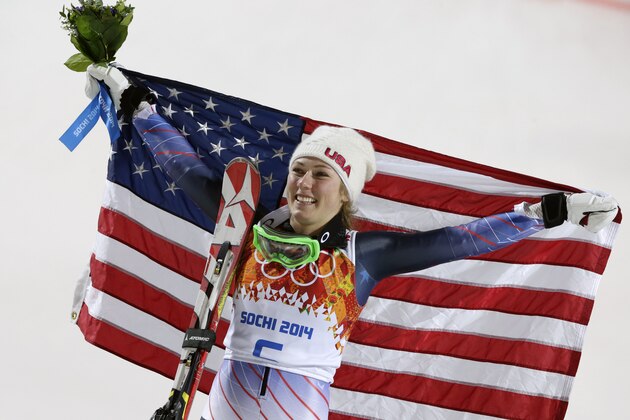 Women's slalom gold medal winner Mikaela Shiffrin of the United States poses for photographers with the U.S. flag at the Sochi 2014 Winter Olympics, Friday, Feb. 21, 2014, in Krasnaya Polyana, Russia.(AP Photo/Gero Breloer)