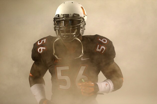 Miami linebacker Raphael Kirby emerges from the smoke as the team takes the field before the start of an NCAA college football game against Virginia Tech, Saturday, Nov. 9, 2013, in Miami Gardens, Fla. (AP Photo/Wilfredo Lee)